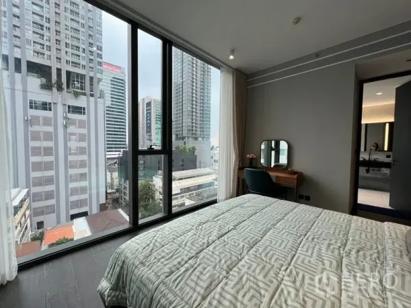 Condominium for rent in Bang Rak, Bangkok - Bedroom with floor-to-ceiling windows, city view and a vanity desk.