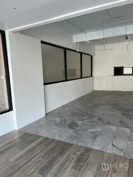 店屋 出租在Wang Thonglang, Bangkok - 开放式营业区，带隔断窗，灰色瓷砖与木纹地板相连。