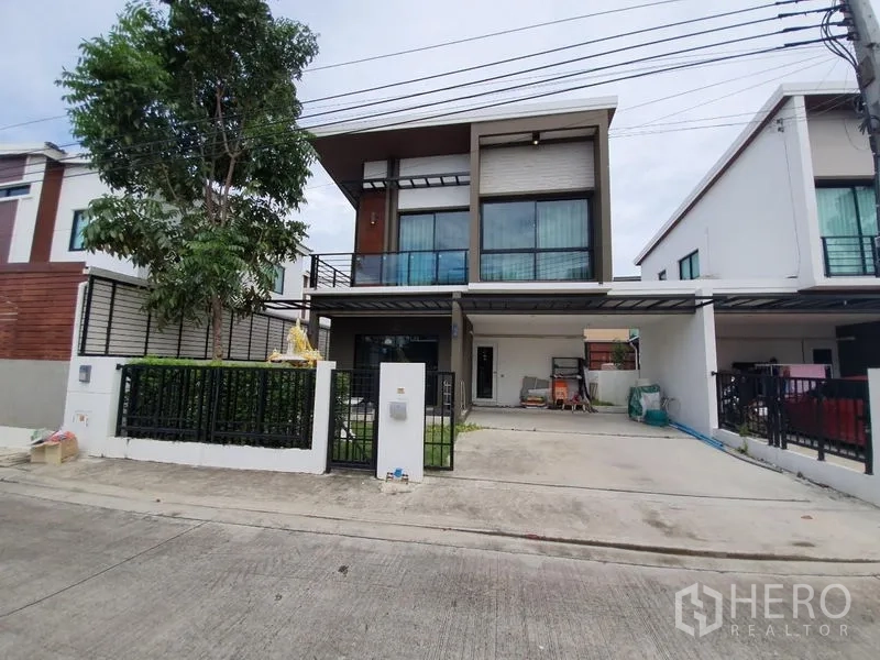 Detached House for sale in Samut Prakan - Modern two-storey detached house exterior with gated driveway and large windows.