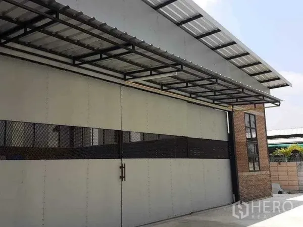 Warehouse for rent in Bang Kapi, Bangkok - Close-up of steel sliding entrance gate with canopy at the warehouse frontage.