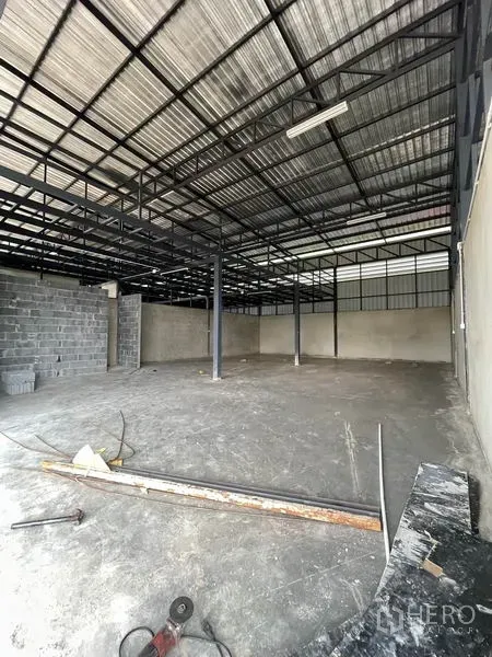 货栈 出租在Pathum Thani - 仓库内部，高钢结构屋架、混凝土地面与立柱。