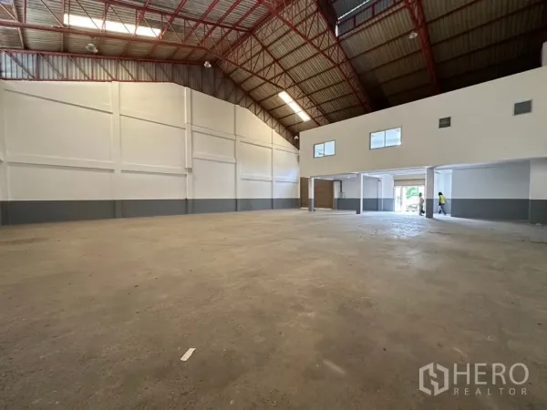 Factory for rent in Bang Sao Thong, Samut Prakan - Open production hall with high ceilings and a mezzanine office block at the entrance.