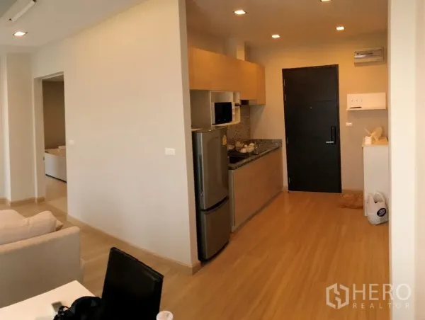 Condominium for sale in Khan Na Yao, Bangkok - Compact kitchenette with granite countertop, mosaic backsplash, microwave and stainless fridge.