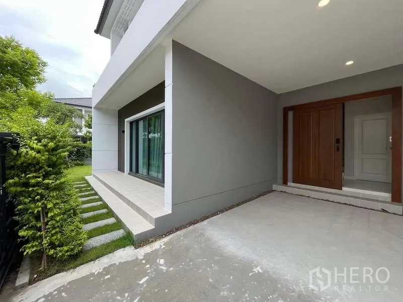 Detached House for rent in Don Mueang, Bangkok - Covered terrace and main entry beside sliding glass doors facing the garden.