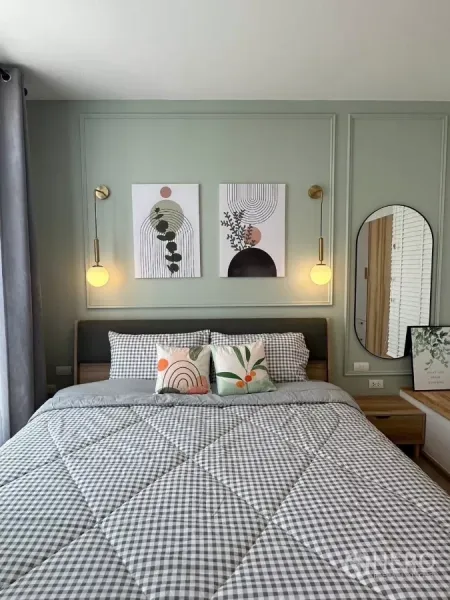 ทาวน์เฮาส์ ให้เช่าในBang Phli, Samut Prakan - มุมเตียงห้องนอนใหญ่พร้อมภาพตกแต่งและโคมแขวนบนผนังสีเขียวซอฟต์