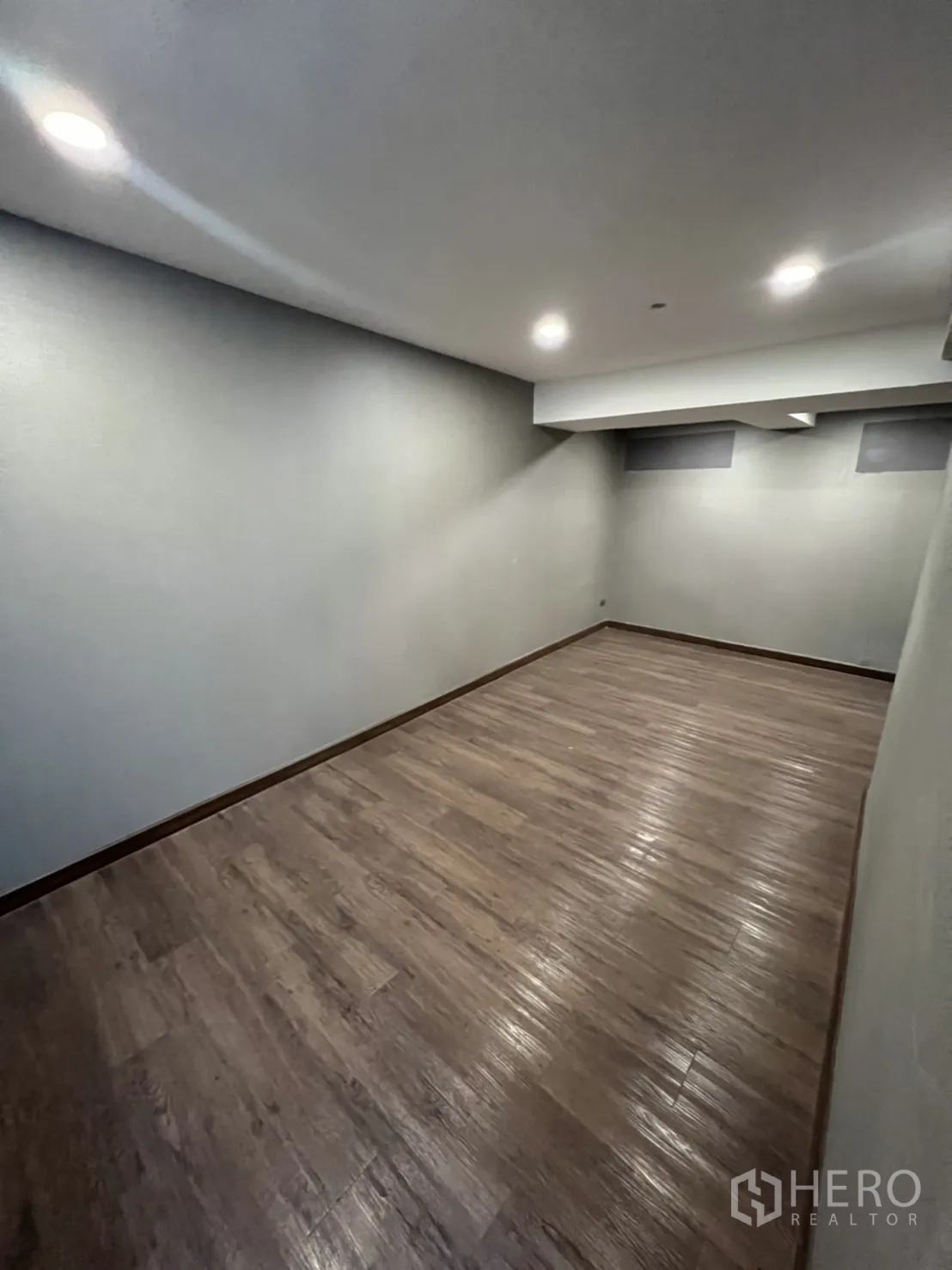 店屋 出租在Phra Khanong, Bangkok - 长条形多功能房，木纹地与筒灯照明。