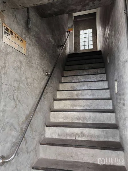 Warehouse for rent in Huai Khwang, Bangkok - Concrete stairwell with metal handrail leading to the upper floor.