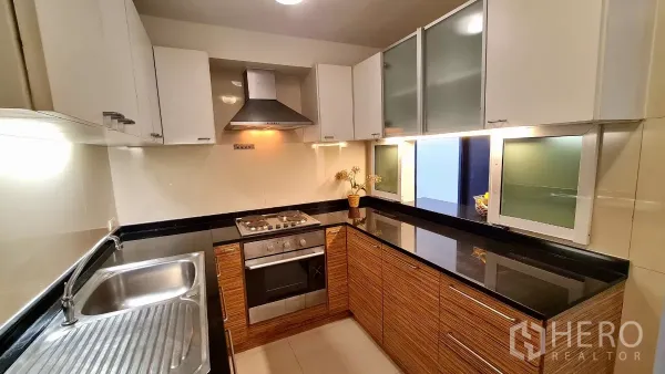 อพาร์ทเมนท์ ให้เช่าในWatthana, Bangkok - ครัวรูปตัวแอลครบชุด มีเตาอบ เตา เครื่องดูดควัน และตู้เก็บของมากมาย