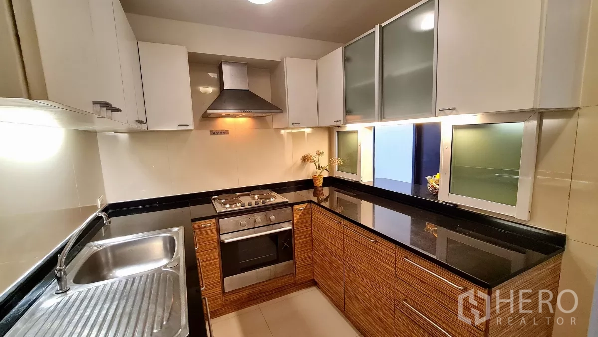 อพาร์ทเมนท์ ให้เช่าในWatthana, Bangkok - ครัวรูปตัวแอลครบชุด มีเตาอบ เตา เครื่องดูดควัน และตู้เก็บของมากมาย