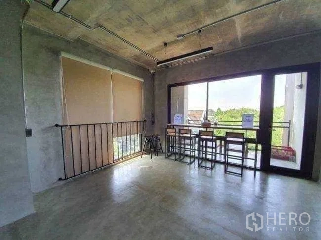 Office Space for rent or sale in Lak Si, Bangkok - Breakout space with bar seating by sliding doors opening to a balcony.