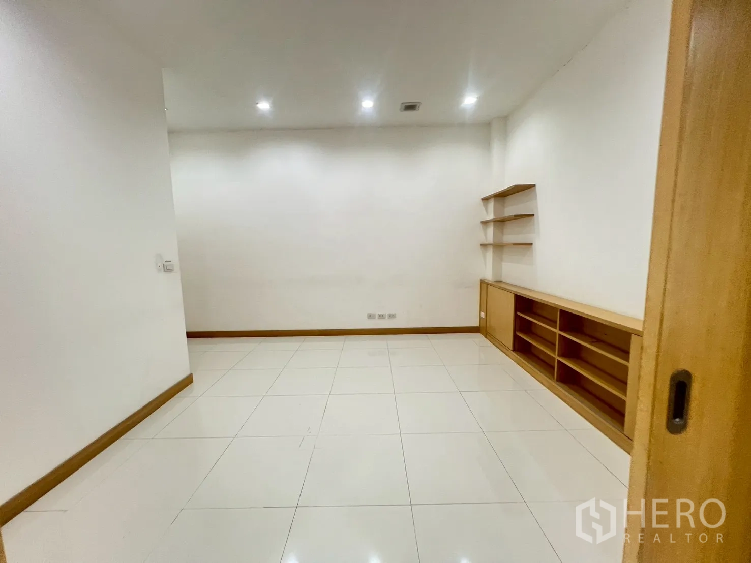 พื้นที่ขายของ for rent in Watthana, Bangkok - ห้องโล่งพื้นกระเบื้องขาว มีชั้นวางและตู้เก็บของบิวท์อินต่ำ