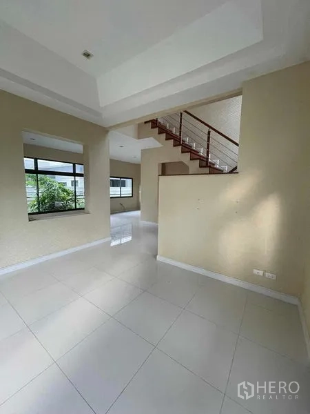 บ้าน ขายในLat Krabang, Bangkok - โถงทางเข้าพร้อมหน้าต่างบานใหญ่และบันไดไม้ขึ้นสู่ชั้นบน