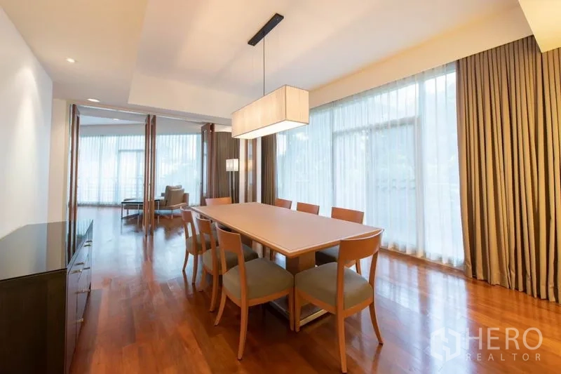 Condominium for rent - Bright dining area with six-seat table, pendant light and sheer drapes.