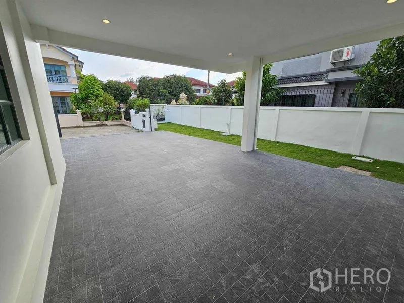Detached House for sale in Thanyaburi, Pathum Thani - Spacious covered carport and terrace facing the gated front yard.