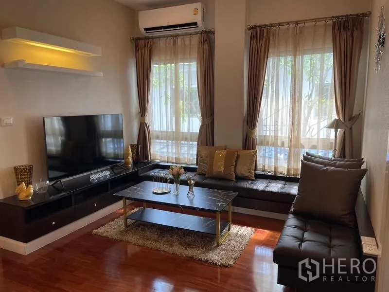 บ้าน ขายในLat Krabang, Bangkok - ห้องนั่งเล่นพร้อมผนังทีวี เบาะนั่งบิวท์อิน และหน้าต่างบานใหญ่