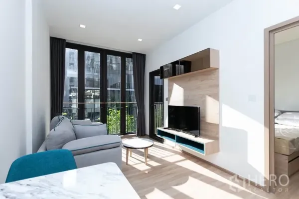 คอนโด ให้เช่าในWatthana, Bangkok - พื้นที่นั่งเล่นพร้อมชั้นทีวีติดผนัง ประตูบานเลื่อนเชื่อมห้องนอน