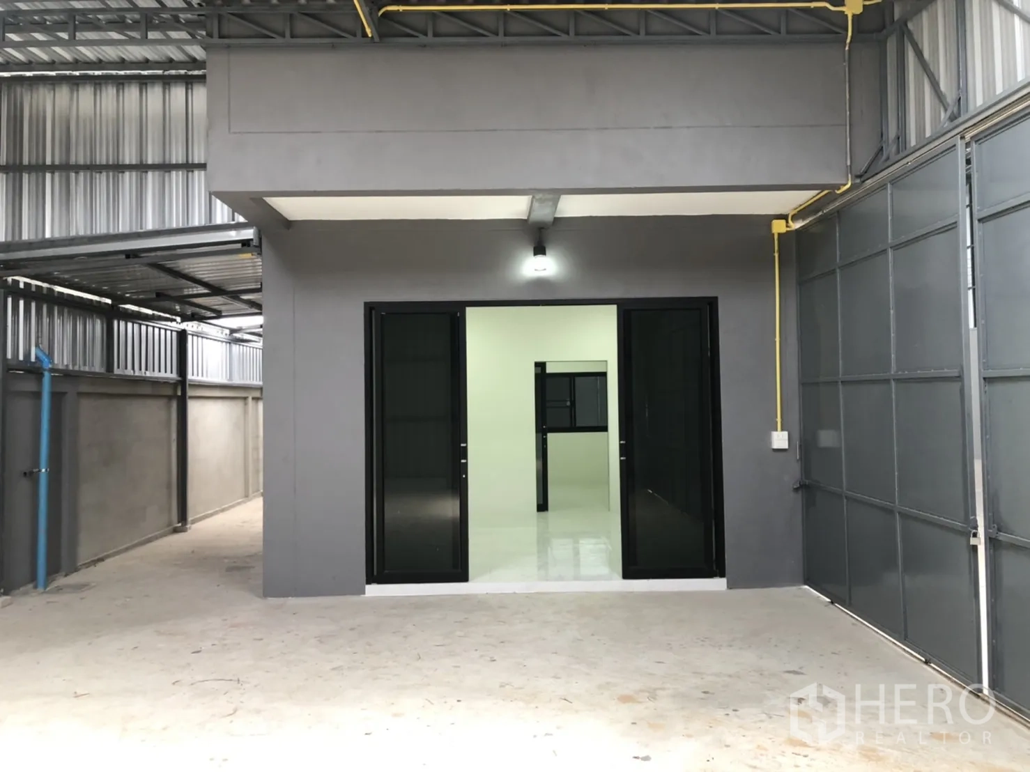 คลังสินค้า ให้เช่าในLam Luk Ka, Pathum Thani - ด้านหน้าออฟฟิศภายในโกดัง ประตูกระจกกรอบอลูมิเนียมสีดำ ใกล้ประตูเหล็กขนาดใหญ่