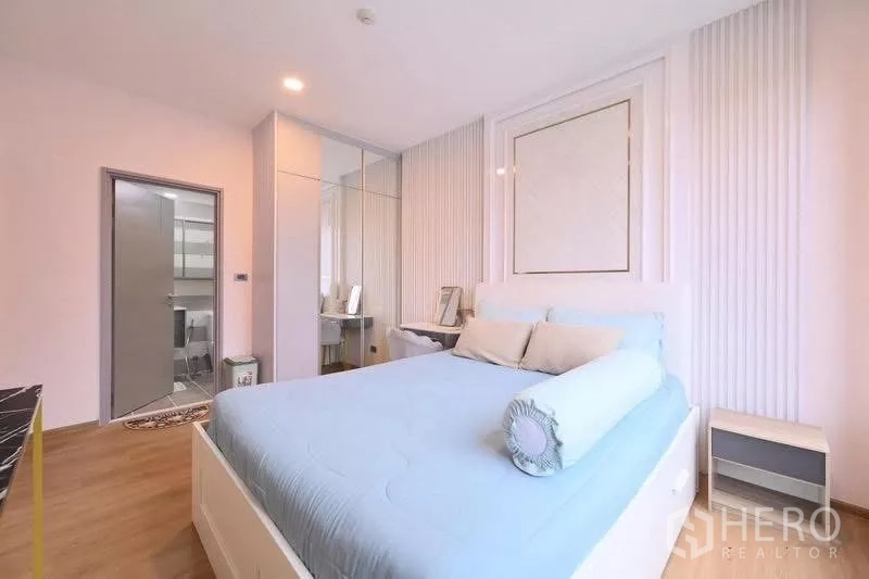 Condominium for rent in Watthana, Bangkok - Bedroom angle showing built‑in wardrobe with mirrors and access to the bathroom.