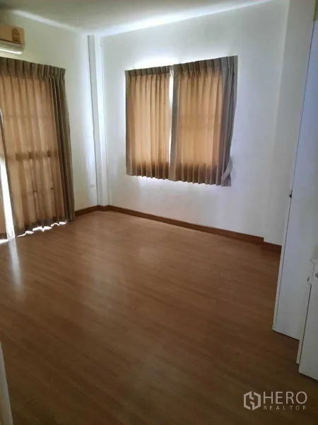Home Office for rent in Watthana, Bangkok - Spacious room with two curtained windows and laminate wood floor.