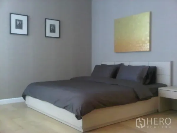 公寓 出售在Ratchathewi, Bangkok - 第二卧室，灰色寝具、浅木地板与墙面艺术品。