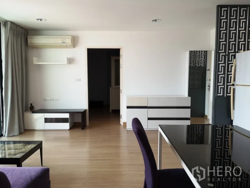 คอนโด ขายในWatthana, Bangkok - พื้นที่นั่งเล่นกว้าง แอร์ ตู้ชั้นวางบิลต์อิน และทางเข้าห้องนอน พื้นไม้