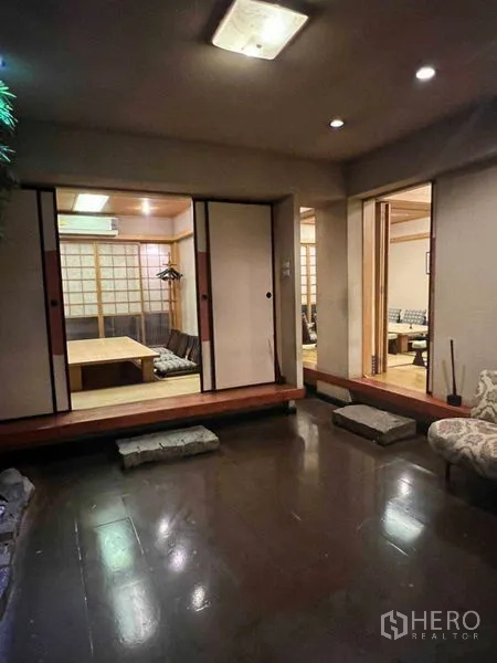 อาคารพาณิชย์ ให้เช่าในKhlong Toei, Bangkok - มุมมองผ่านดอกไม้ไปยังห้องตาตามิที่มีเบาะและโต๊ะเตี้ย