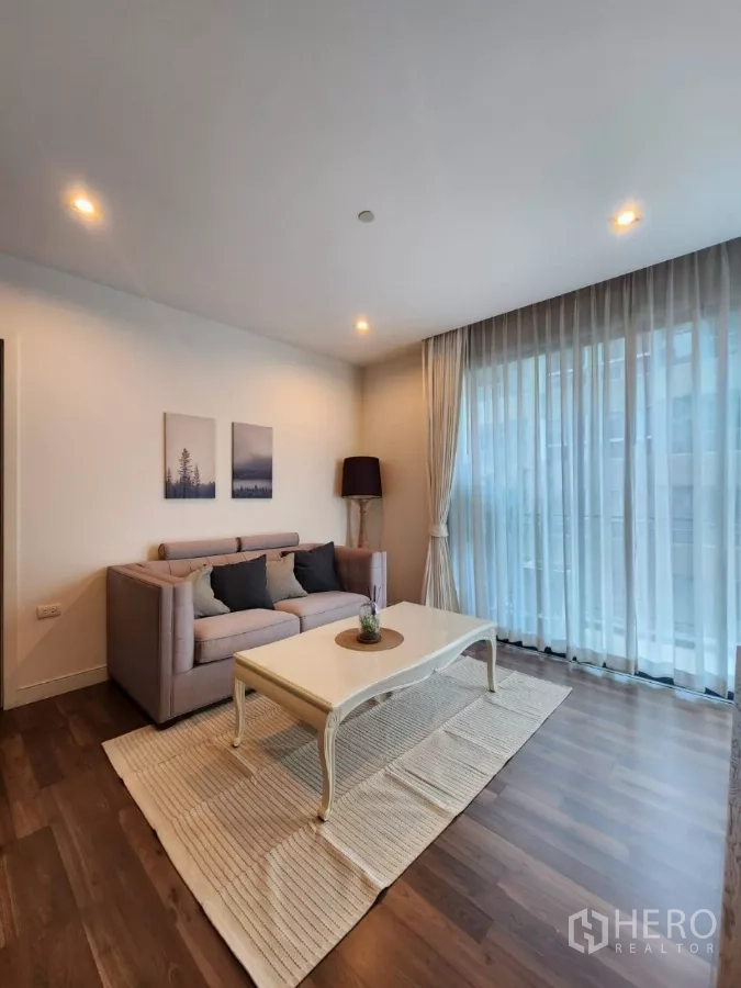 คอนโด ให้เช่าในPhra Khanong, Bangkok - ห้องนั่งเล่นกว้าง โซฟา โต๊ะกาแฟสีครีม พรม และหน้าต่างเต็มผนัง