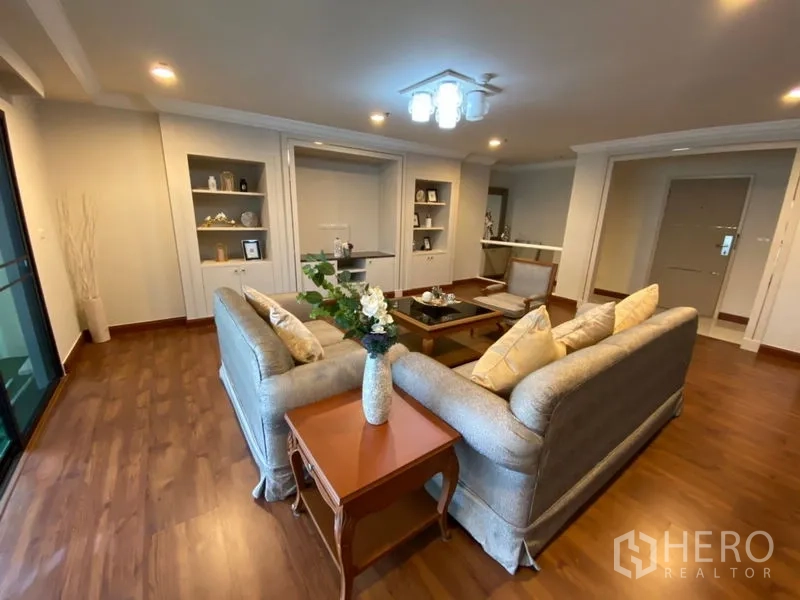 คอนโด ให้เช่าในWatthana, Bangkok - ห้องนั่งเล่นอบอุ่นพร้อมโซฟาชุด ตู้โชว์บิวต์อิน และประตูออกสู่ระเบียงกว้าง