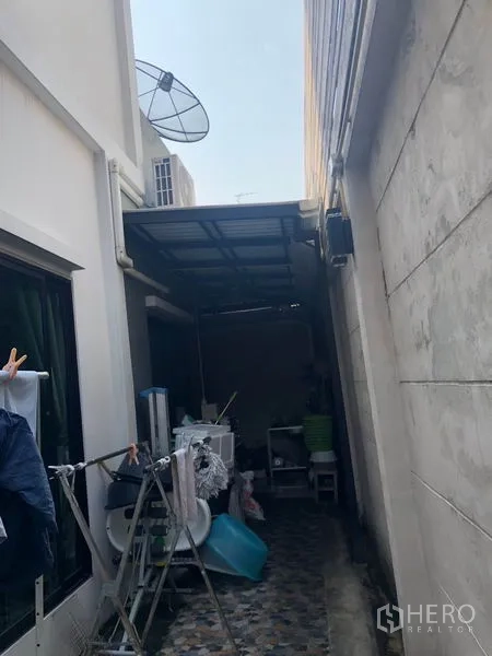 Townhouse for sale in Phasi Charoen, Bangkok - Narrow side yard with roof cover, laundry drying area and storage.