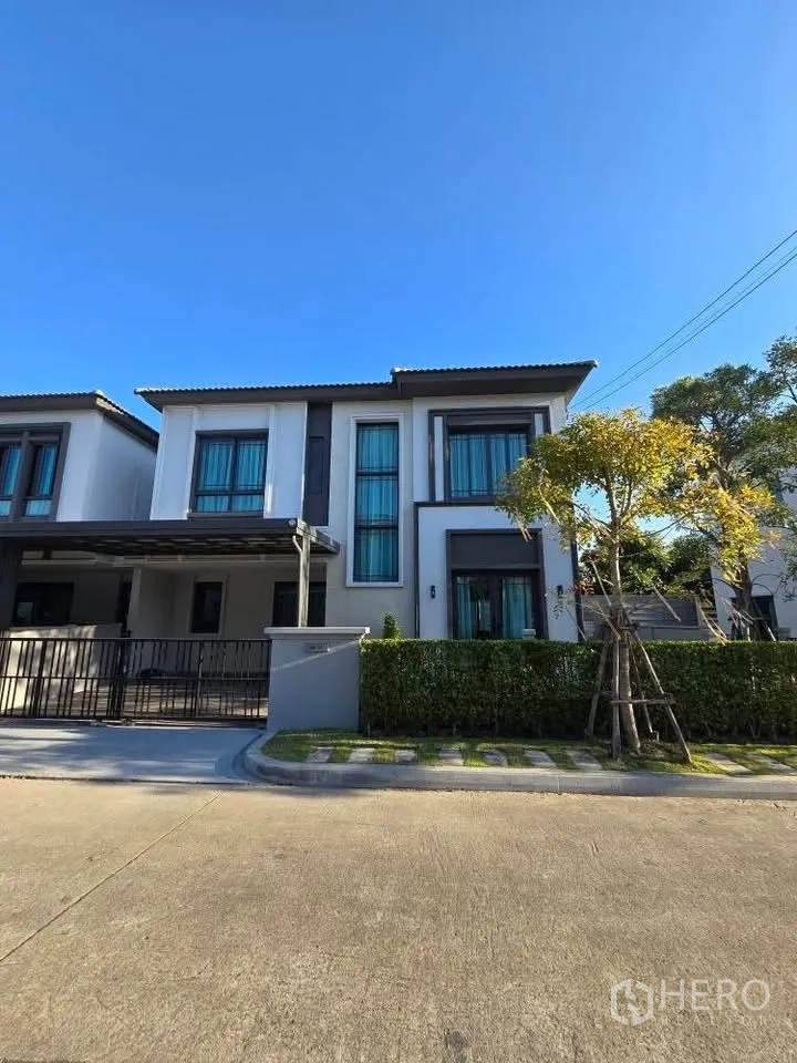 Semi-detached House for rent in Bang Phli, Samut Prakan - Street view of the modern semi-detached home with front garden and clear sky.