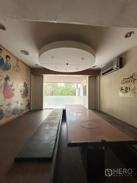 零售空间 出租在Yan Nawa, Bangkok - 日式榻榻米风格包房，低桌、墙面装饰与阳台景观。