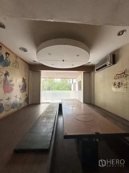 零售空间 出租在Yan Nawa, Bangkok - 日式榻榻米风格包房，低桌、墙面装饰与阳台景观。