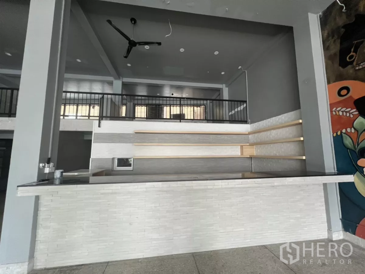 อาคารพาณิชย์ ให้เช่าในWatthana, Bangkok - เคาน์เตอร์ด้านหน้าพร้อมชั้นวาง ใต้เพดานสูงมีพัดลมและชั้นลอย.