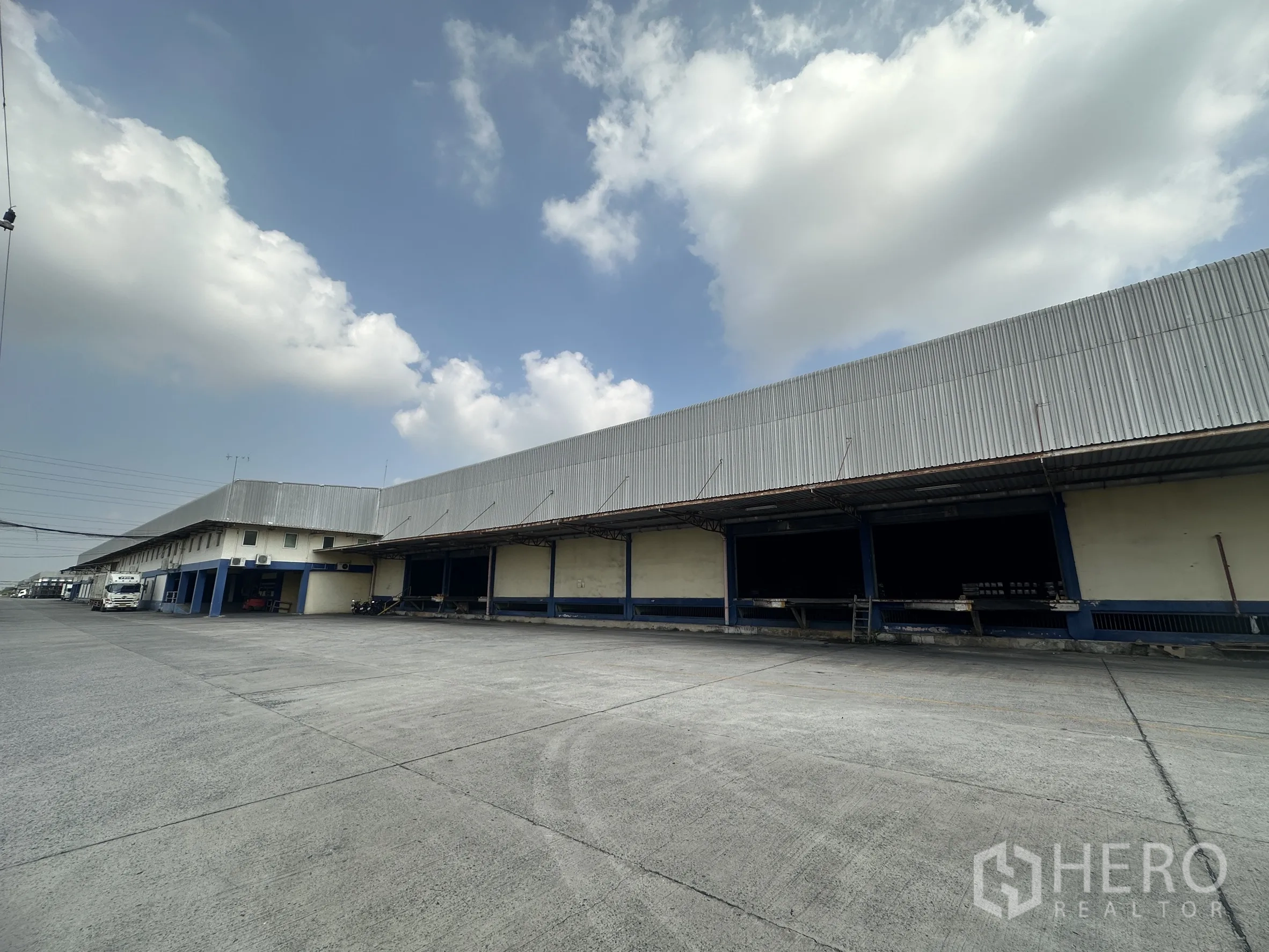 仓库 for rent in Bang Pa-in, Phra Nakhon Si Ayutthaya - 仓库外立面设有有顶装卸月台和宽阔的卡车停泊与调度场地。