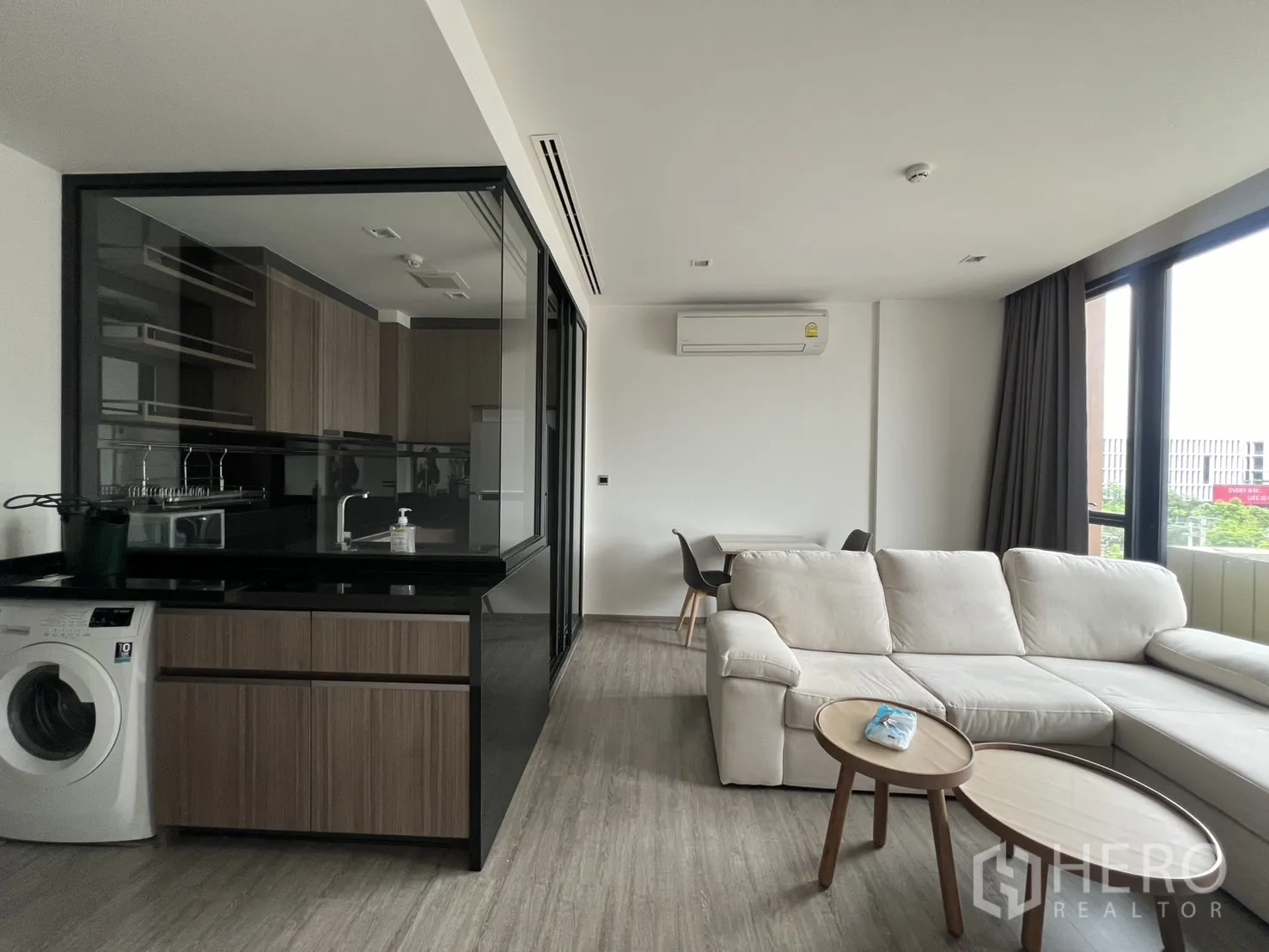 คอนโด for rent in Watthana, Bangkok - พื้นที่โอเพ่นแพลนพร้อมเคาน์เตอร์ครัวและเครื่องซักผ้า โซฟา ชุดโต๊ะทานอาหาร และหน้าต่างสูง