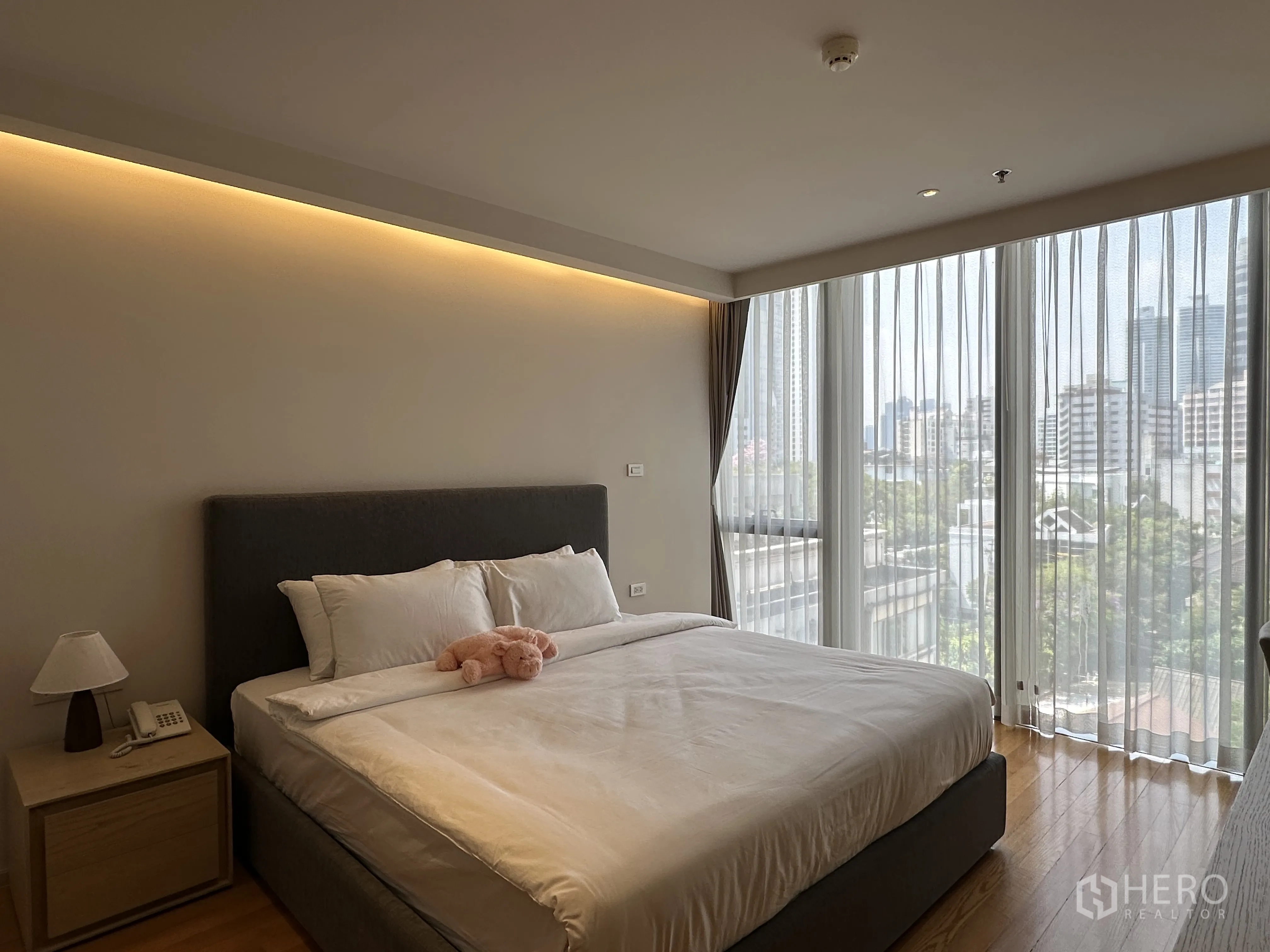 คอนโด for rent in Khlong Toei, Bangkok - ห้องนอนหลักสว่างพร้อมหน้าต่างเต็มผนัง วิวเมือง และเตียงคิงไซซ์