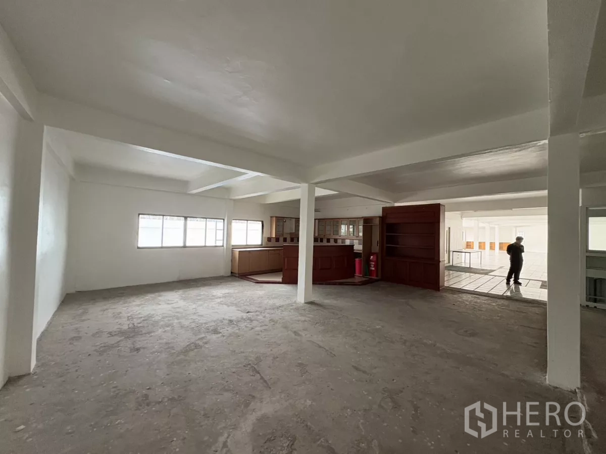 办公空间 出租在Watthana, Bangkok - 宽阔的未完成办公区，带窗户与木制柜台。