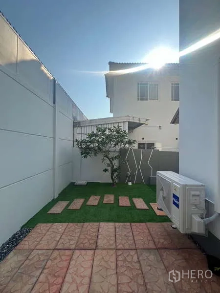 บ้าน ให้เช่าในBang Kapi, Bangkok - ลานหลังบ้านสนามหญ้าขนาดเล็ก แผ่นทาง และคอมเพรสเซอร์แอร์