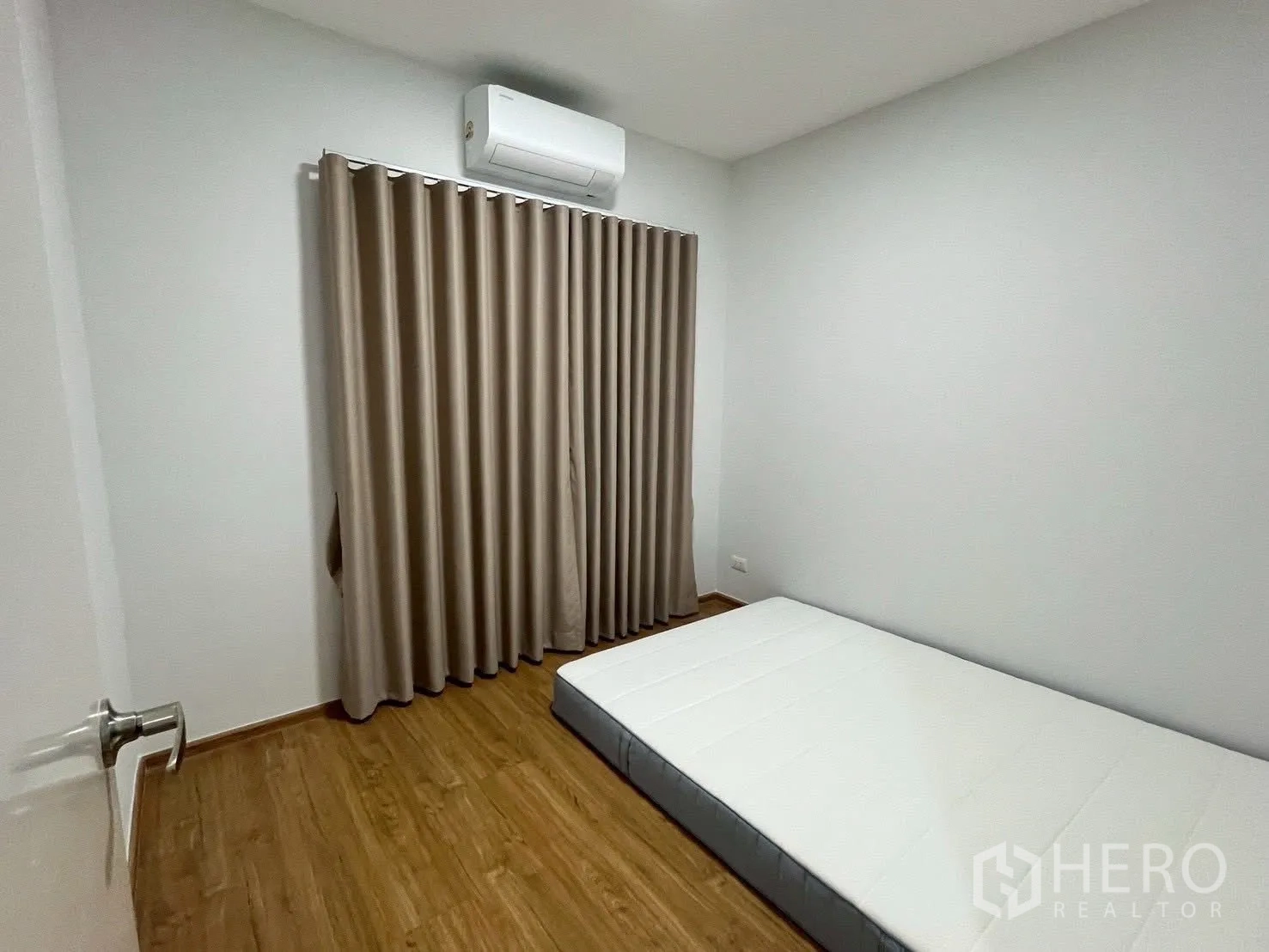 联排别墅 for rent in Bang Phli, Samut Prakan - 卧室内放置地铺床垫，配窗帘与空调。