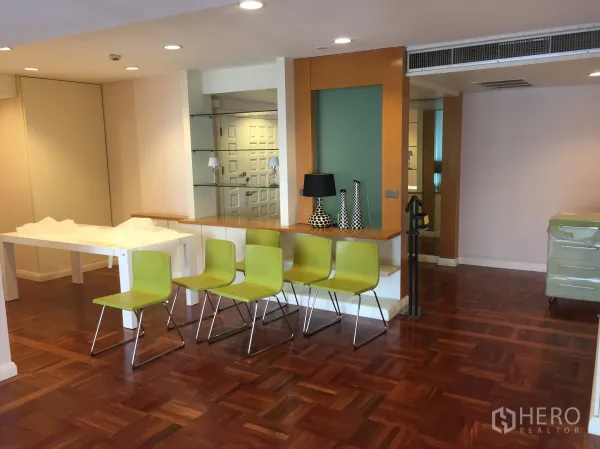Condominium for rent in Pathum Wan, Bangkok - Open-plan living and dining area with parquet floors, breakfast bar and recessed lighting.