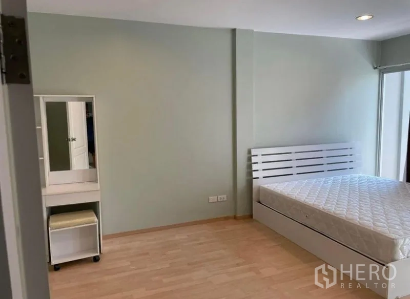 ทาวน์เฮาส์ ให้เช่าในSuan Luang, Bangkok - ห้องนอนพร้อมเตียงสีขาวและที่นั่งเครื่องแป้ง มีทางออกสู่ระเบียง