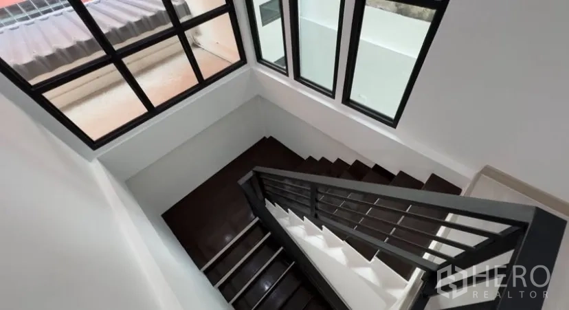 Detached House for rent in Suan Luang, Bangkok - Top view of the stairwell framed by large corner windows bringing natural light.