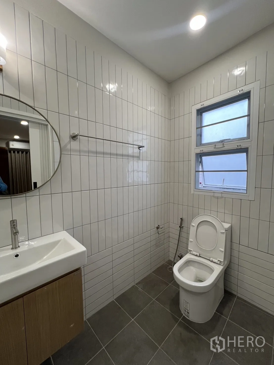 Detached House for rent in Saphan Sung, Bangkok - Ensuite shower room with grab bars and vanity along tiled wall.