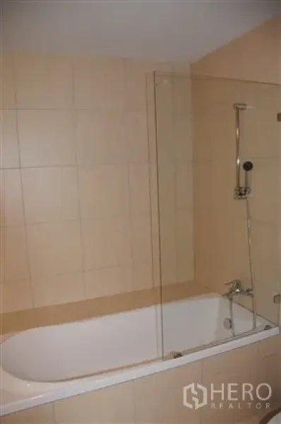 公寓 出租在Khlong Toei, Bangkok - 卫浴配浴缸、手持花洒与透明玻璃挡板。
