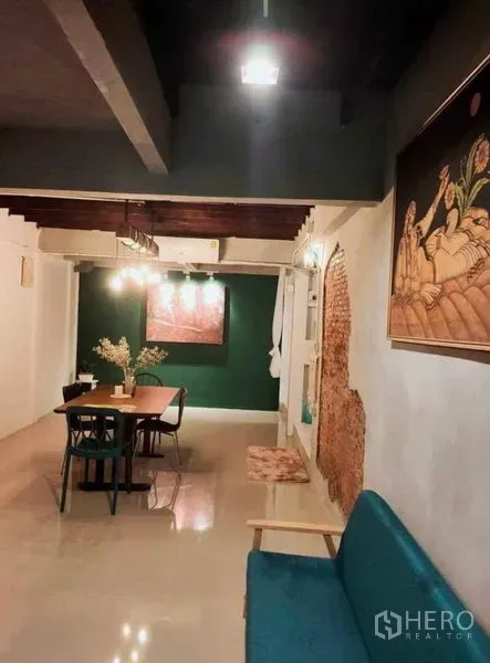 Detached House for rent in Pathum Wan, Bangkok - Open-plan living and dining with glossy floors, teal bench seating and rustic brick accents.