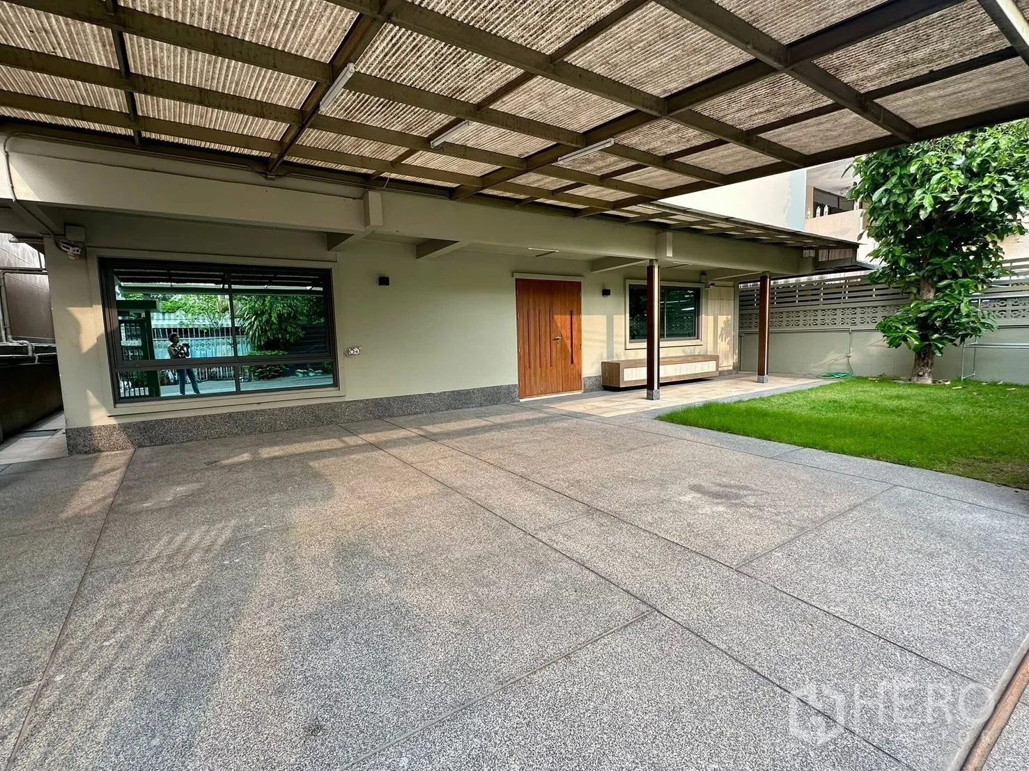 บ้าน for rent in Watthana, Bangkok - ที่จอดรถในร่มและชานบ้านหน้า พร้อมสนามหญ้าเล็กและต้นไม้ใหญ่