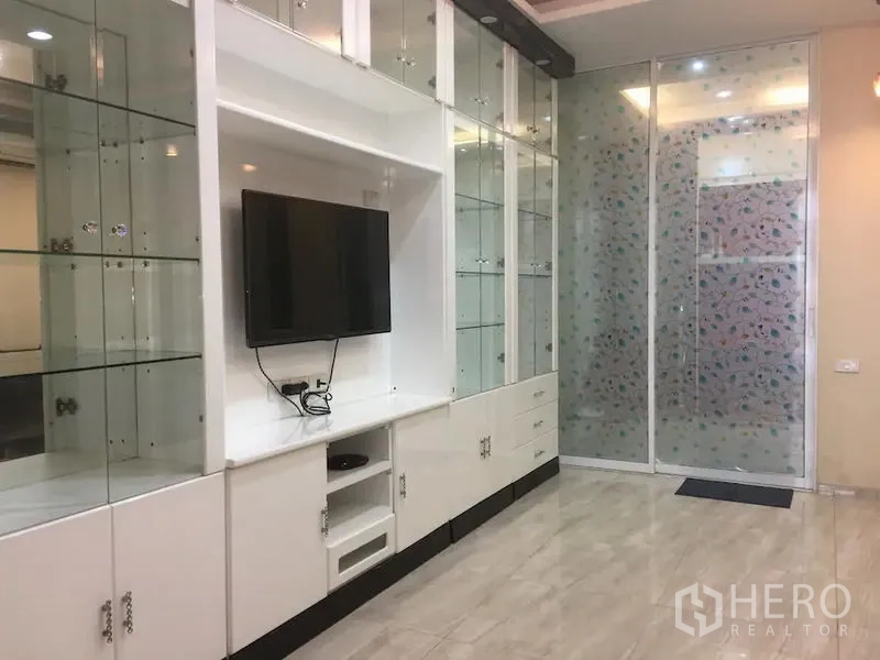 ทาวน์เฮาส์ ให้เช่าในBang Rak, Bangkok - ตู้บิลท์อินสีขาวพร้อมชั้นกระจก ทีวีติดผนัง และประตูกระจกฝ้า