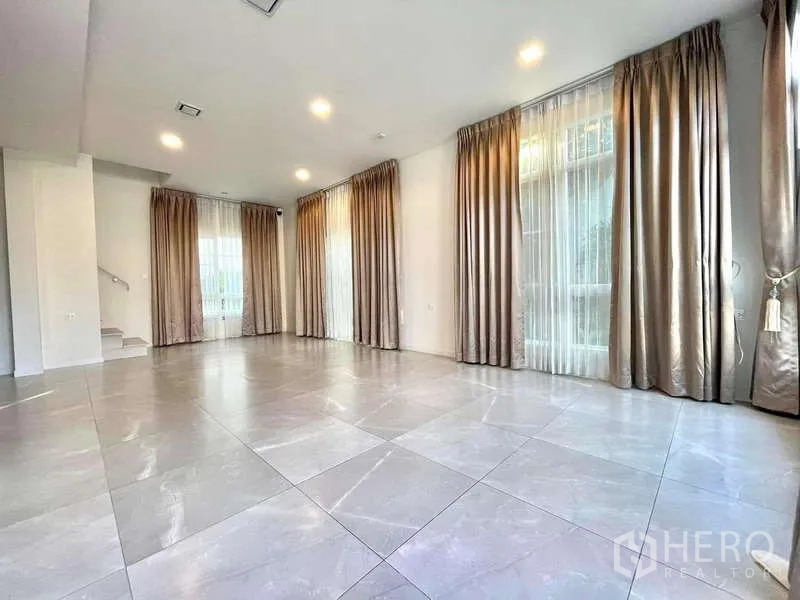 บ้าน ให้เช่าในPrawet, Bangkok - ห้องนั่งเล่นกว้าง พื้นกระเบื้องแผ่นใหญ่ หน้าต่างเต็มบาน ผ้าม่าน และไฟดาวน์ไลท์.