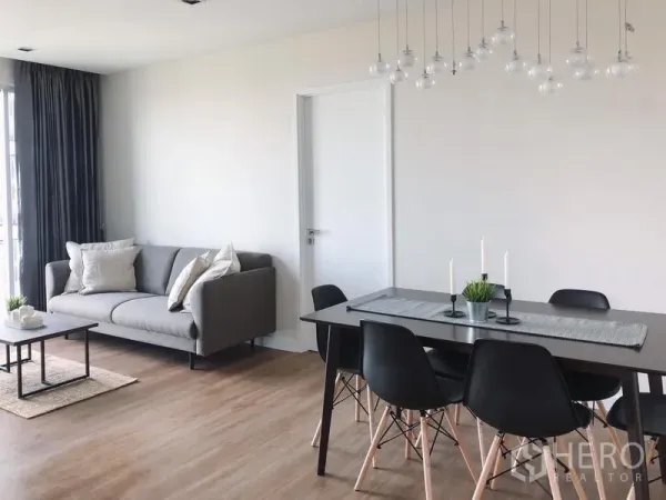 คอนโด ให้เช่าในBang Rak, Bangkok - ห้องนั่งเล่นและรับประทานอาหารสว่าง โปร่ง โซฟาสีเทา ชุดโต๊ะดำ โคมไฟห้อย และพื้นไม้