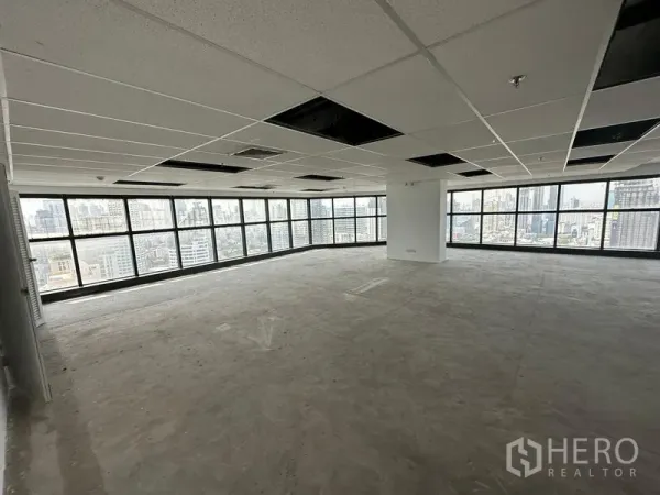 办公空间 出租 - 未配家具的整层平面，吊顶与多面窗墙，背景为城市天际线。